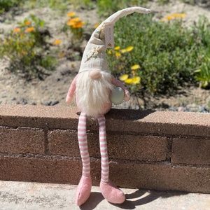 Pink and ivory sitting Easter Gnome with long legs holding Easter Egg